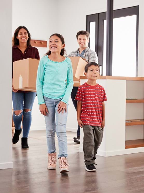 Family of four walking into their new home.